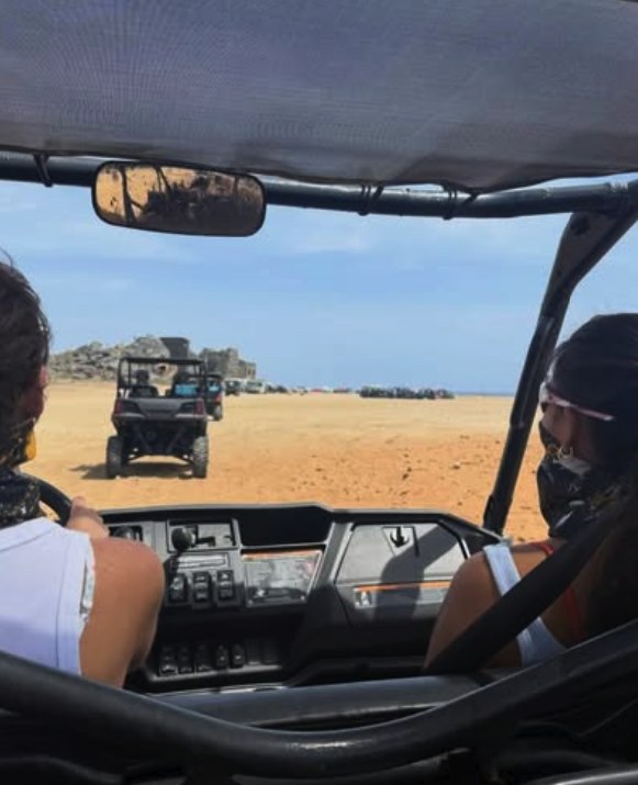 A UTV convoy crossing open ground on Aruba's north coast, outside the park boundary